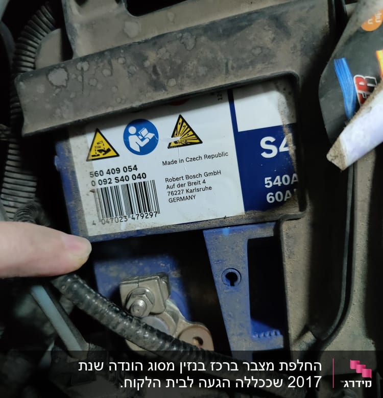 מצבר רכב עם תוויות אזהרה וחוטים מחוברים